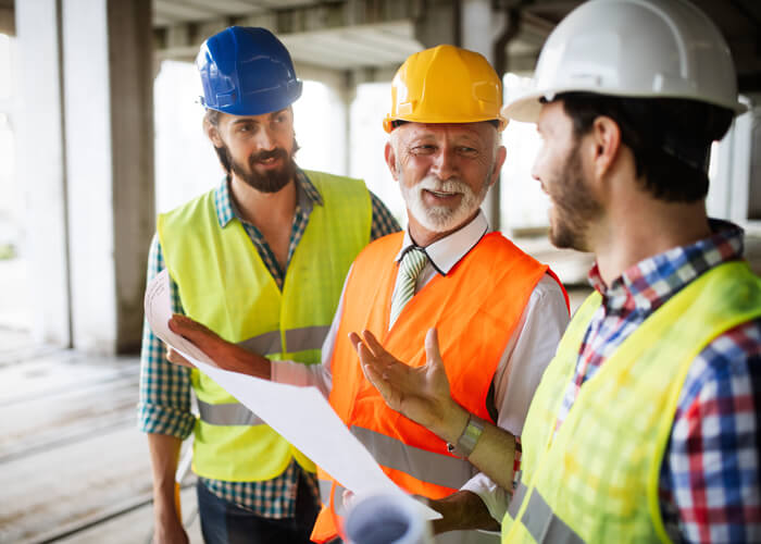Three construction workers having meeting